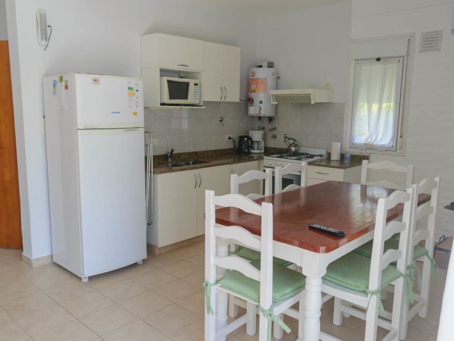 Cocina y comedor integrados de la cabaña para 6 personas, con mesada de granito