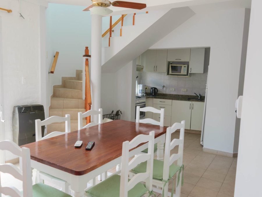 Comedor y cocina equipada de la cabaña para 8 personas, con escalera a la planta alta