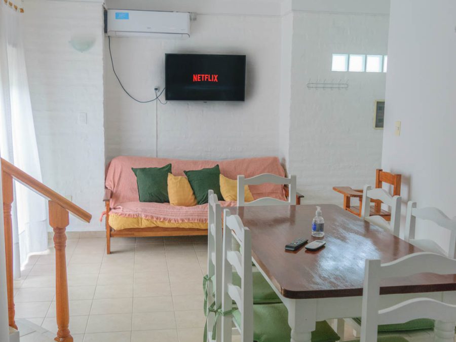 Living comedor de la cabaña para 8 personas con TV, sofá y escalera a la planta alta