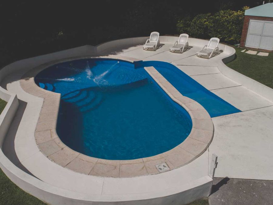 Pileta con solárium y reposeras en el complejo de cabañas
