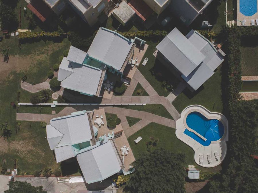 Vista aérea cenital del complejo Los Prados con las cuatro cabañas y la pileta
