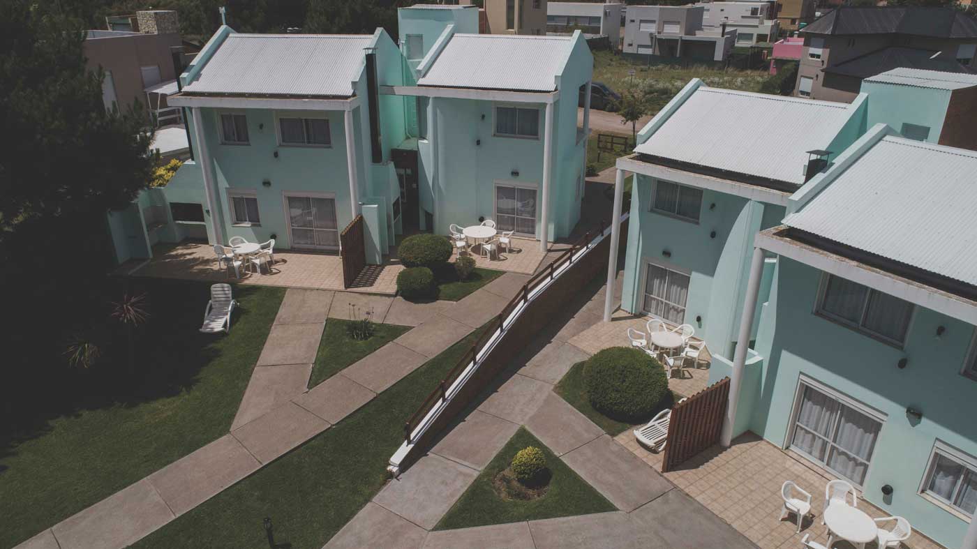 Vista aérea del complejo Cabañas Los Prados con sus galerías y el parque, en Monte Hermoso